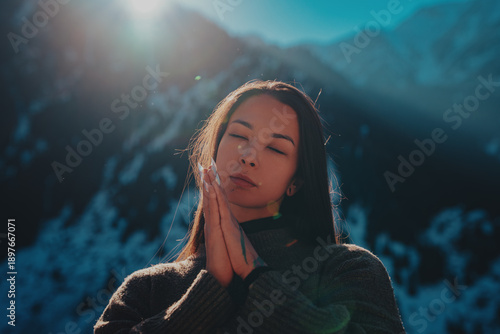 Young woman spiritual portrait in high snowy mountains on winter day
