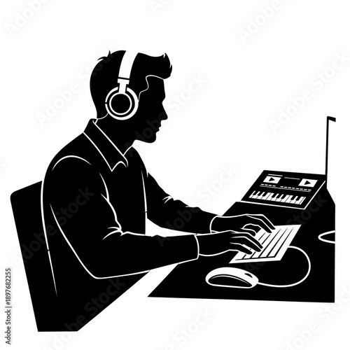 Man working on computer with headphones on desk.