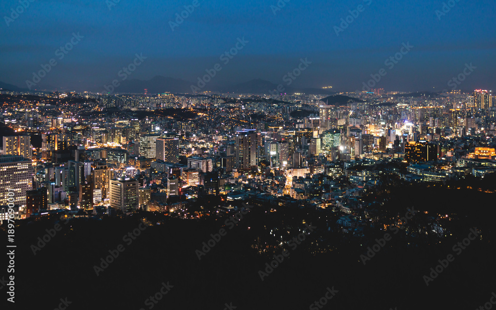 Fototapeta premium Seoul night skyline, South Korea, beautiful aerial twilight view, with mountains and scenery beyond the city, seen from observation deck of Namsan Park, Gyeonggi-do province, Republic of Korea