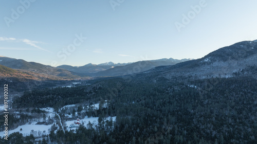 Aerial view of the Adirondack Mountains in New York during winter, with snow-covered forests.