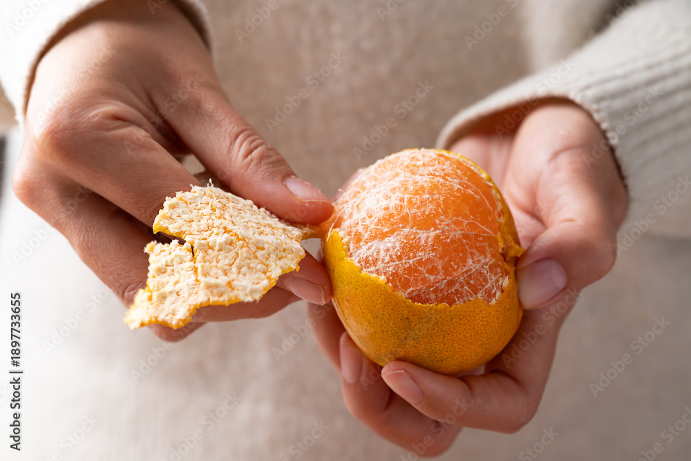 Obraz premium Mandarin orange fruit peeling by hand and eating