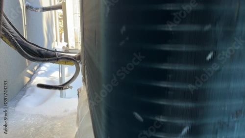 Frozen Heat Pump Unit Covered in Thick Ice and Snow. A close-up shows a heat pump base encased in thick ice and icicles, highlighting severe freezing conditions affecting outdoor HVAC units.