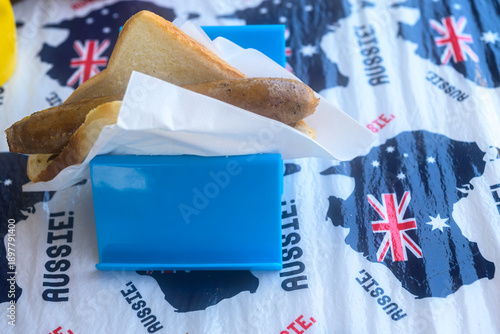 Принти на полотні A classic Australian sausage sizzle served on white bread in a blue holder, featuring a patriotic Aussie-themed tablecloth