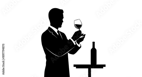 Man in suit examining wine glass with bottle on table beside him