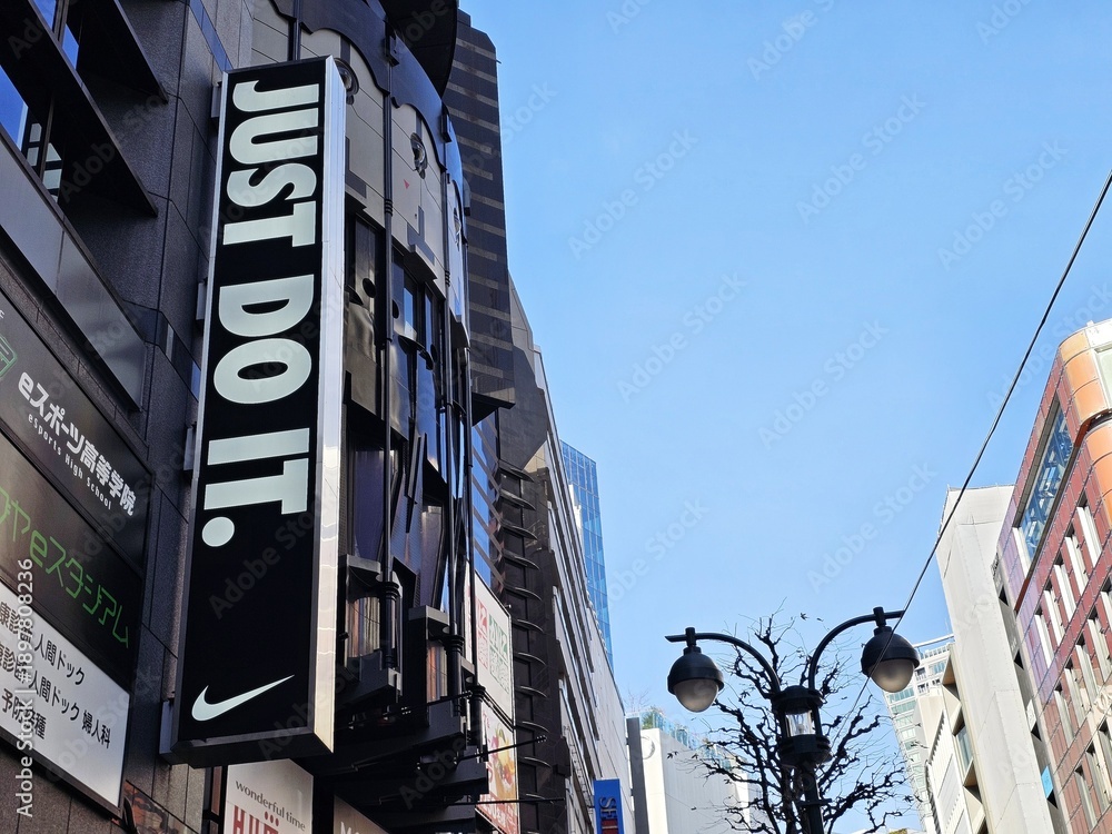 Fototapeta premium Tokyo, Japan - January 15, 2026: Nike Just Do It Signage in Shibuya, Tokyo, Japan Nike is an American famous athletic footwear, was founded in January 25, 1964.