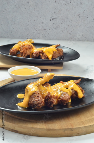 Photography Tebasaki is a fried chicken wing dish typical of Nagoya, Japan, served with a drizzle or dip in a savory creamy cheese sauce
