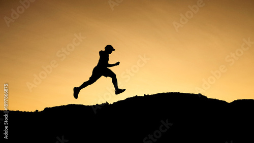 Wallpaper Mural Silhouette of a runner mid-air against an orange sky background. Showcasing determination and the pursuit of a goal. The individual is in motion Torontodigital.ca