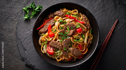 Top View of Beef Lo Mein Noodles with Vegetables in a Dark Bowl.