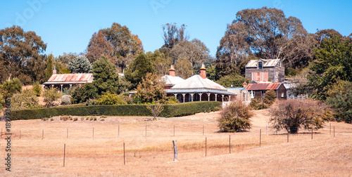 Landscape view of  Australian country homes with wide verandahs and brown grass