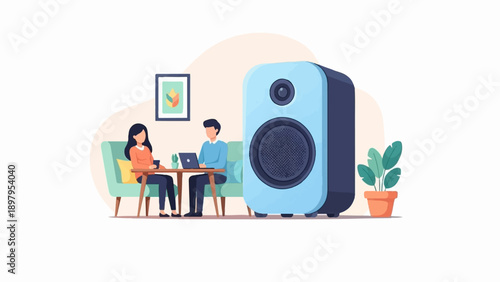 Two people sitting at a table with laptops, near a speaker and a plant