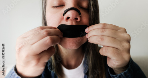 Obraz na płótnie Latina woman using nasal strip and mouth tape for better sleep and breathing - B