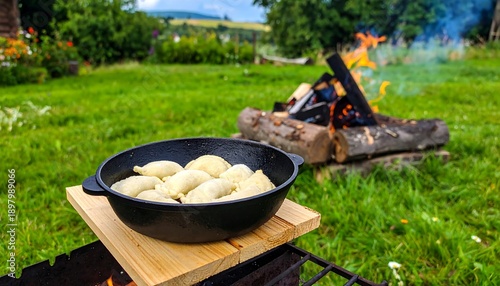 Delicious Dumplings Cooking Over an Open Fire in a Rustic Outdoor Setting.