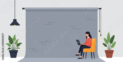 Woman in orange sweater uses laptop in a photo studio with plants