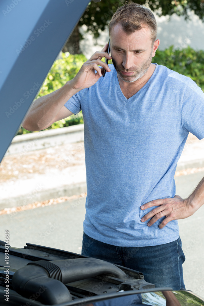 Obraz premium man with broken down car calling somebody for help