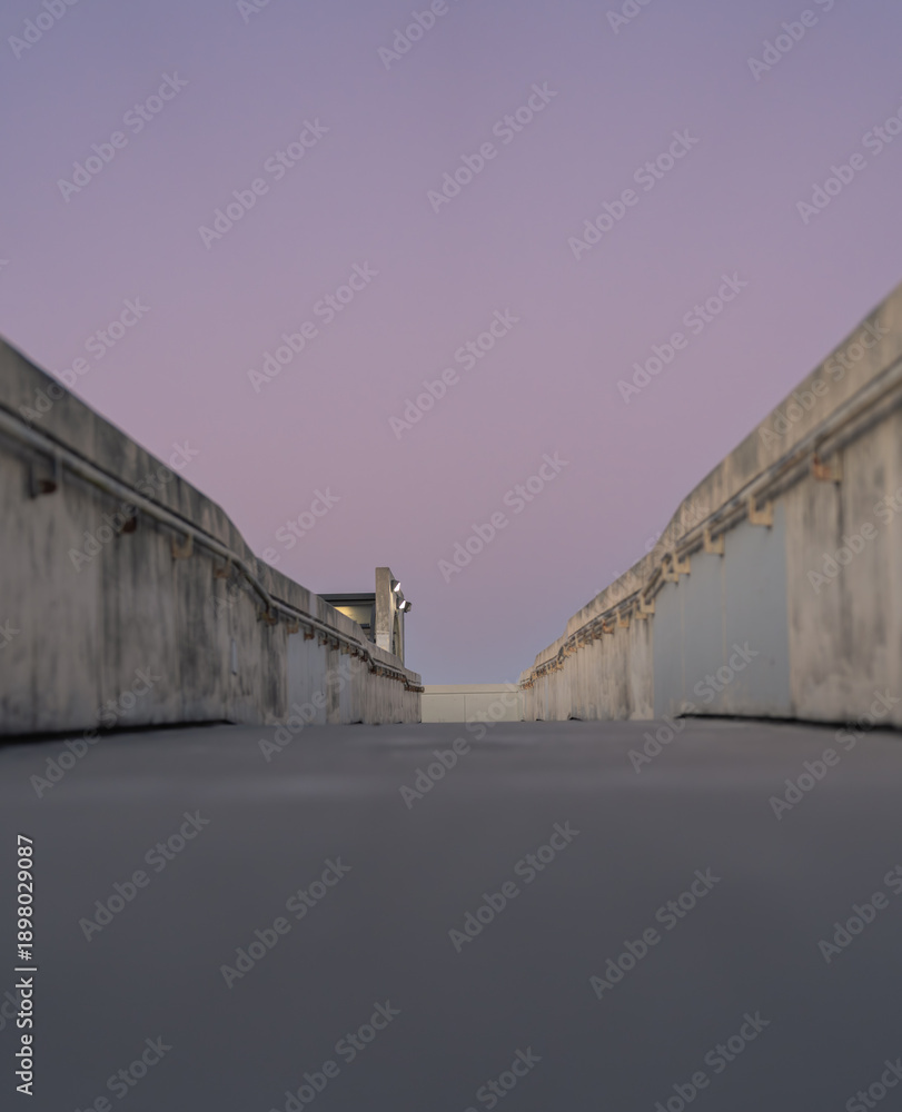 Naklejka premium Minimal concrete walkway with symmetrical walls under pastel space