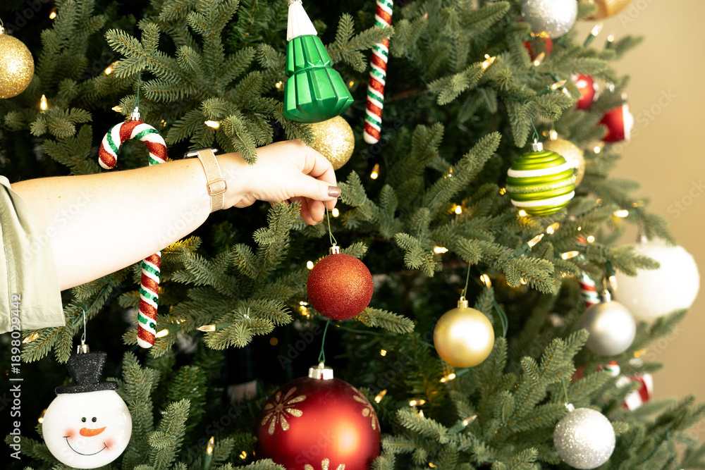 Naklejka premium Woman decorating a Christmas tree