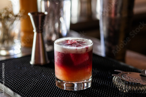 Tableau sur toile Red orange mixed drink on bar top with accessories