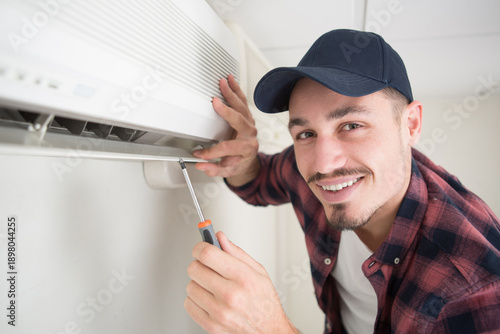 Принти на полотні portrait of mid-adult male technician repairing air conditioner