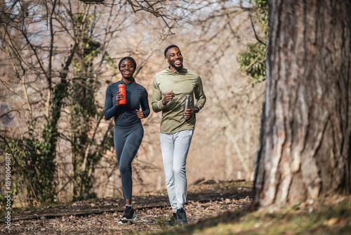 Happy couple running outdoors on a nature trail