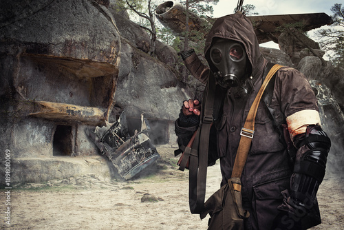 man in gas mask wandering through abandoned settlement.