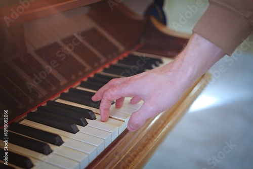 Unrecognizable person play an piano. Closeup with selective focus.	