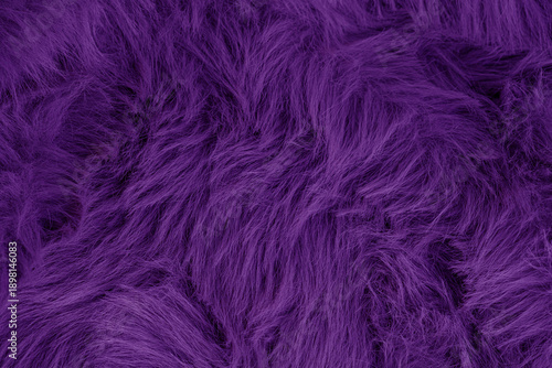 Close up view of luxurious deep purple shaggy faux fur textile fabric material plush soft background