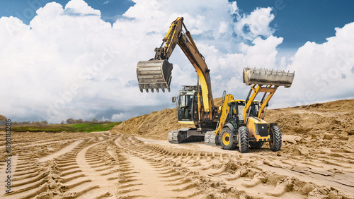 Fotografía Heavy machinery leaves deep tracks in the sandy ground as loaders and excavators