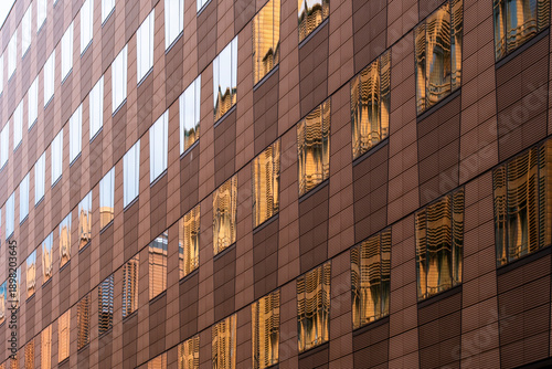 Urban corporate office architecture building facade with window grid in brown tones capturing warm light for modern business district exterior background