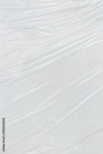 Crumpled white plastic or cellophane sheets in an abstract arrangement. Great for background textures, packaging design, or artistic concepts.