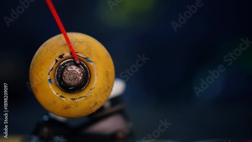 Close up of spraying lubricant into a skateboard wheel bearing, Maintenance of skateboard equipment.