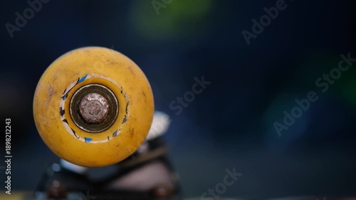 skateboard wheel spinning and slowing down on a desk, close up macro shot with blur background.
