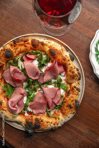 Obraz na plátně Italian style pizza topped with roast beef arugula and melted cheese served on w