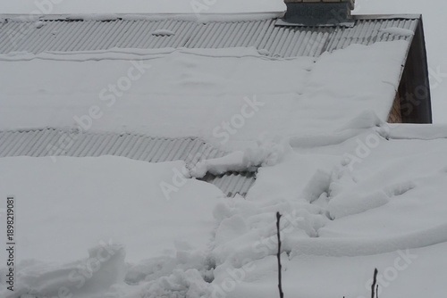 compacted snow is lying on the roof and is sliding down.