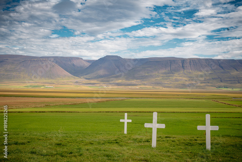 three crosses on the hill with mountains in the distance