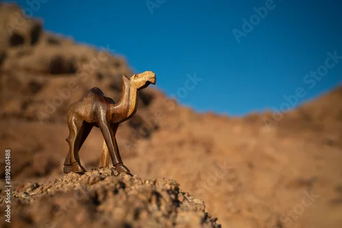 Fototapeta Rzeźba wielbłąda na tle skał i błękitnego nieba – pustynny krajobraz w słoneczny dzień