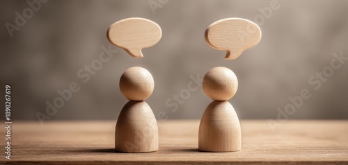 The wooden figures engaged in conversation with speech bubbles representing dialogue and communication