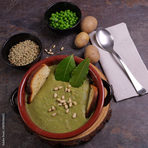 Ciotola con passato di piselli e lenticchie con pinoli e pane tostato, ingredienti nelle ciotola