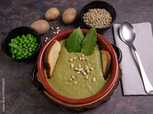 Ciotola con passato di verdura e ingredienti sul tavolo