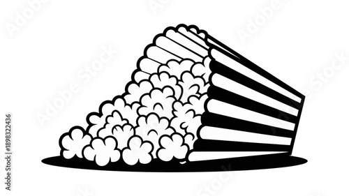 A classic striped box of cinema popcorn tips over, with fluffy kernels spilling out onto a surface.