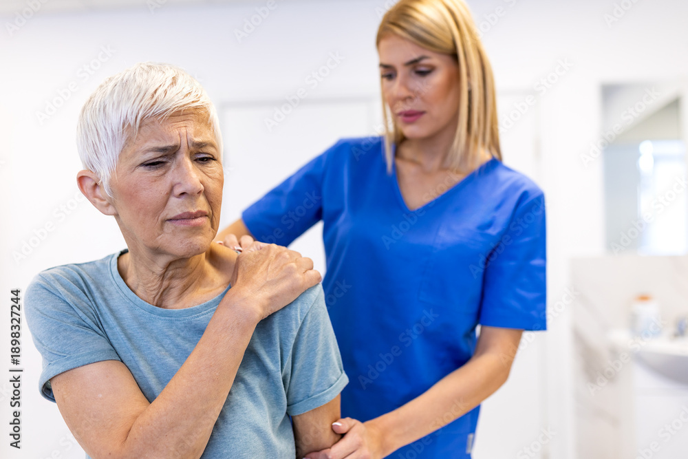 Obraz premium Pain in the shoulder. Upper arm pain, people with body-muscles problem, healthcare and medicine concept. Female physical therapist examining painful shoulder of senior woman in medical clinic.