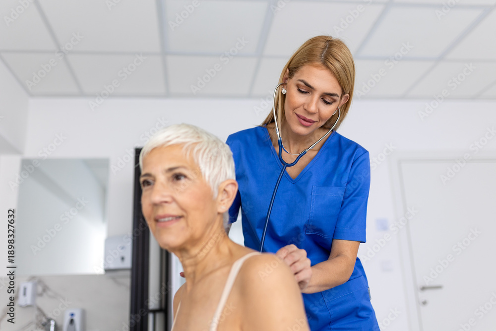 Obraz premium Female Doctor Examining Senior Patient's Back with Stethoscope for Respiratory Checkup, Professional Medical Auscultation for Elderly Woman, Healthcare Diagnostic Procedure in Modern Clinic