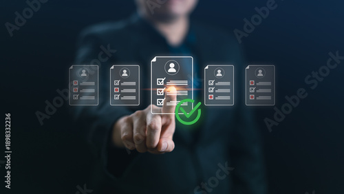 Businessman selecting the best candidate profile with a green check mark on a virtual screen. Concept of recruitment, human resource management, hiring process, and career talent search.