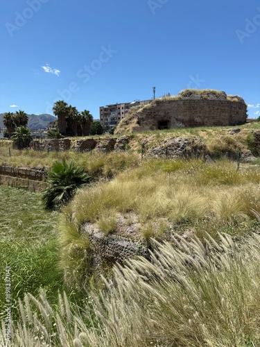 Grassy Ruins and Open Landscape Under Blue Sky in Sicily