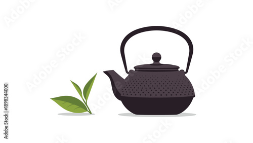 Traditional black cast iron teapot stands next to fresh green tea leaves to represent healthy herbal drink culture.
