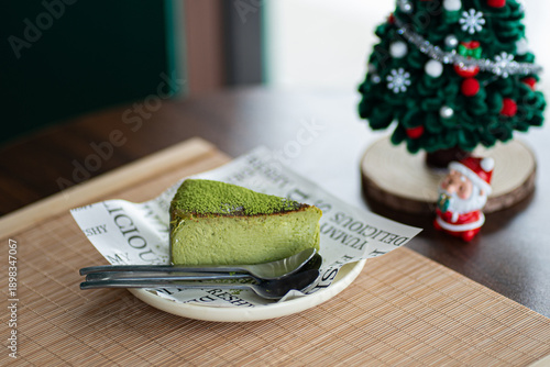 A Slice of Matcha Cake with a  on a Plate on Table.