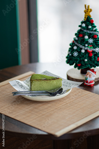 A Slice of Matcha Cake with a  on a Plate on Table.