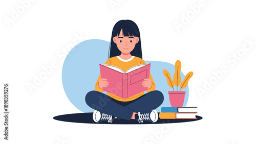 Young girl with long dark hair sitting cross-legged on the floor while being deeply engrossed in reading a large pink book.