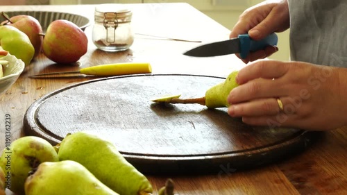 Woman cuts apples and pears for pie
