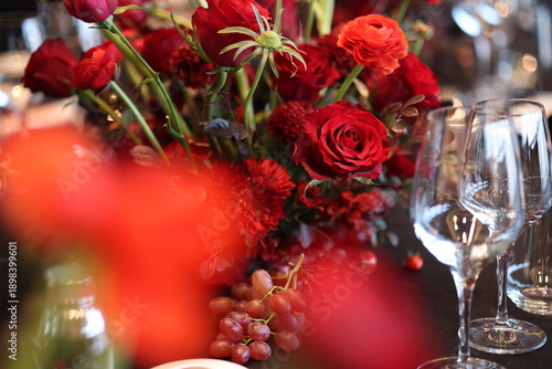 Photos Elegant table setting showcasing rich red floral centerpiece with roses and ranu