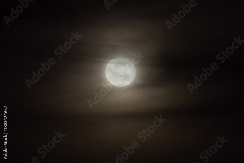 Full moon in the night sky with clouds